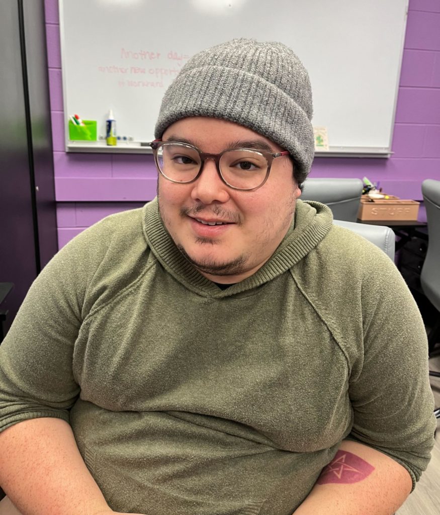 Josh, a Korean-American man wearing glasses and a grey knit beanie smiling.